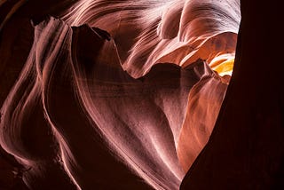 A beautiful heart shaped tunnel through terracotta coloured rock.