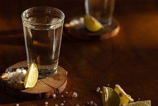 Close-Up Photo of Lime Slices Near Tequila Shots