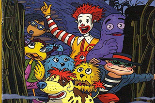 Ronald McDonald, and friends pose in front of a haunted house.