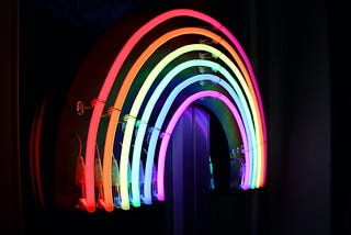 Neon rainbow arcs on black background