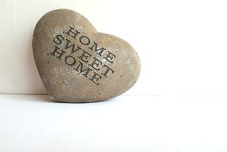 a heart-shaped rock with the words “Home Sweet Home” engraved on it.