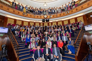 A group photo of attendees of the second International Conference on Newborn Sequencing, in a large auditorium