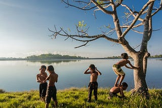 Five boys playing near a body of water