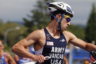 Nick Vandam shown in a biking helmet and apparel, competing in the 2012 Military Triathlon World Championship.