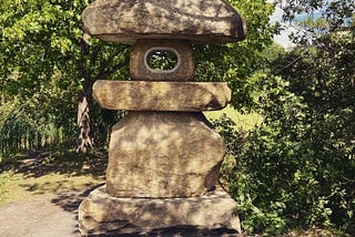 A stone statue surrounded by nature
