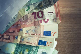 A picture of an envelope with euro bills of various denominations sticking out of it