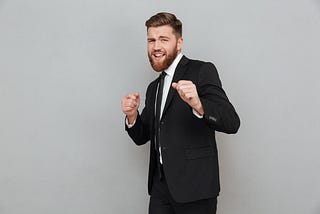 Bearded smiling businessman in suit posing.