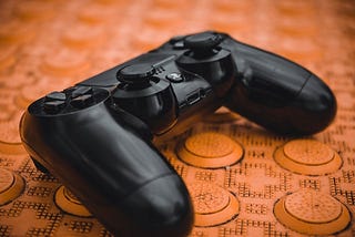 PlayStation video game controller on a brown background