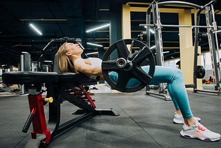 Woman doing glute bridges in a gym