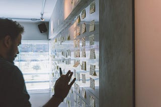 Man at whiteboard posting sticky notes