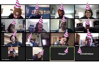 Screenshot of zoom call with people laughing and smiling, with photoshopped pink stripped birthday hats on everyone’s heads.