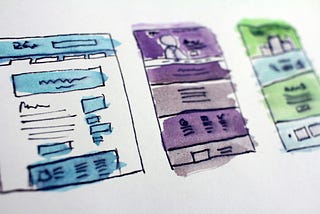 Colorful watercolor sketches of user interface wireframes on paper