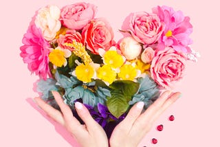 A female holding flowers’ bouquet with her two hands.