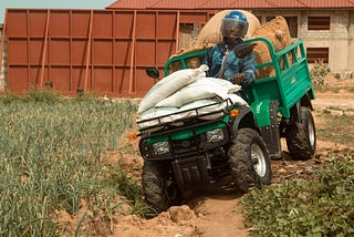 A man riding an ATV through a farmland