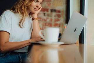 Woman working on laptop in coffee shop