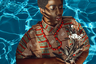 Black child in the pool holding flowers