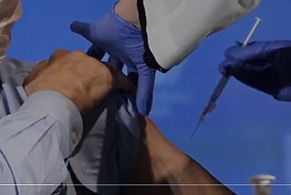 Man taking a vaccine on left arm