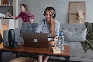 Woman works from home as kids play in the background
