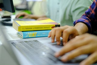 design books at a computer desk