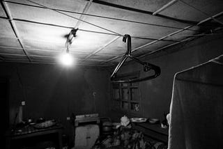 A B&W picture of a clothesline in an old kitchen. The kitchen was the place where families congregated their live on.