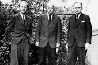 3 German physicists from the 1920s standing in suits for a black and white photo