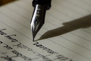 A pen writing down notes on a paper