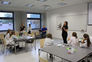 Me holding a robot and explaining something to the group of young girls.