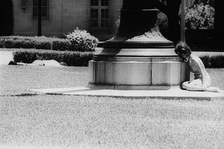 A terrified student hides behind the concrete base of a flagpole during the Aug. 1, 1966 University of Texas mass shooting.