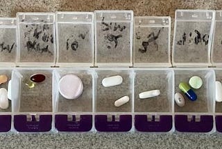A pill box with several pills in each slot