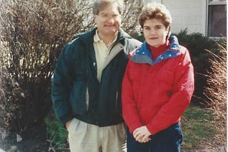 Man and woman in ski jackets standing in front of a house in Springfield, Ohio, USA.