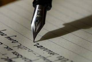 A fountain pen writing on a paper