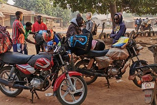 Motorcycles and people on side of road in the morning.