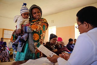 A mother enrolled in MomCare receives a postnatal check-up in Tanzania