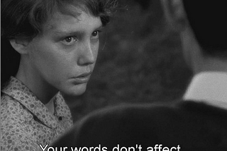 Black and white photo of a young girl is teary and speaking to a man who’s face we can’t see. The subtitle says: Your words don’t affect me anymore. The image is a screenshot from Robert Bresson’s film: Au Hasard Balthazar.