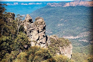 View of the valley in the blue mountains in Australia with the three sisters rock formation in the foreground.
