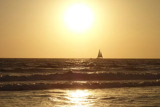 A beautiful, golden sunset with a ship on the ocean