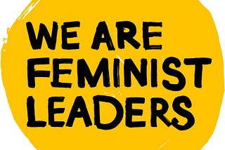 A yellow circle with black text in the middle saying ‘We Are Feminist Leaders’