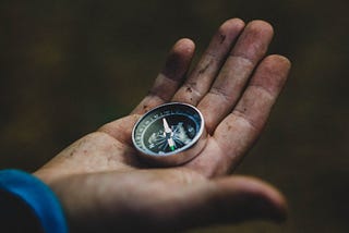 A hand holding a compass