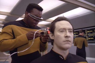Geordi LaForge doing diagnostics on Data on Star Trek