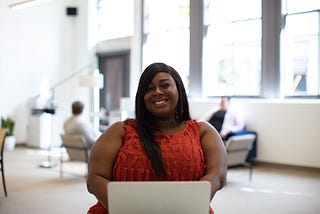 Smiling Black woman at a computer