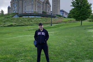 Patrick standing in front of the Cornell University