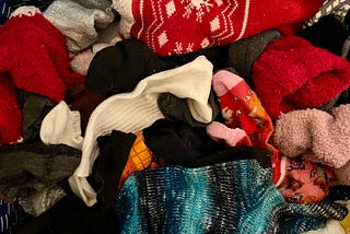 A close-up of a bin filled with loose, colorful socks.