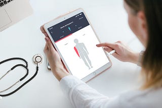 A healthcare professional interacting with a telehealth application on an iPad.