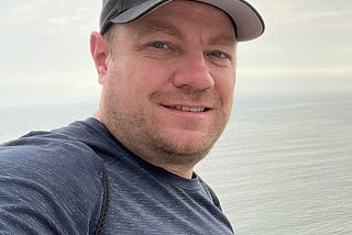This is a picture of Scott Cate in a hat overlooking the oceans of Peru.
