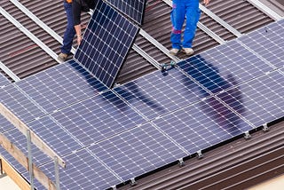 Two workers installing a Tesla solar roof in Cape Coral.