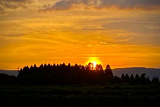Sun setting over a mountain range in the distance