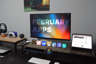 Image of a desk with a monitor hanging on the wall showing a wallpaper of the space. Eight app icons below the monitor on top of a desk shelf. An iPad on the right side, gadgets on the left and a mouse and keyboard below the shelf on the desk.