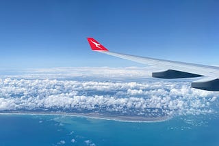 The view heading into Auckland airport. Clear blue water and white clouds suspended above the landscape.