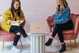 Two women in a meeting looking at a laptop