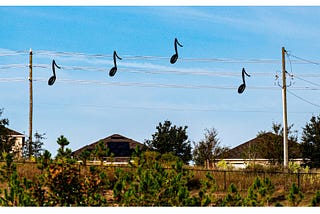 Picture of power lines with musical notes on them.